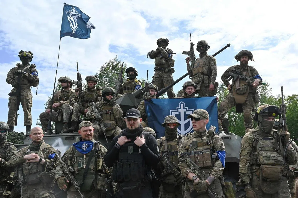 TOPSHOT - The founder of the Russian Volunteer Corps, Denis (C), known as "White Rex", flanked  by fighters in camouflage attend a presentation for the media in northern Ukraine, not far from the Russian border, on May 24, 2023, amid Russian military invasion on Ukraine. Russian nationals fighting on Ukraine's side on May 24 hailed as a "success" a brazen mission to send groups of volunteers across the border into southern Russia and back. Russia on May 23 said it deployed jets and artillery to fight off armed attackers who crossed into the southern region of Belgorod from Ukraine, exposing weaknesses on Moscow's frontier. (Photo by SERGEY BOBOK / AFP)