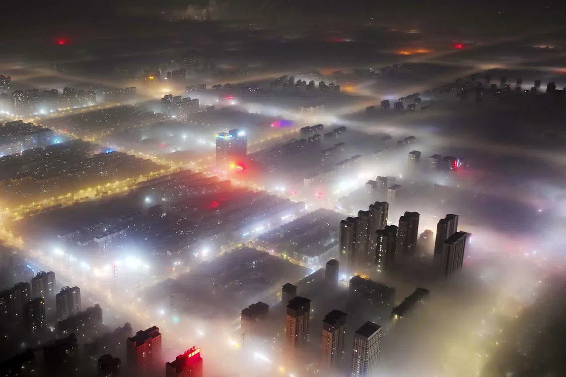 TOPSHOT - The aerial photo taken on November 20, 2024 shows a general view of buildings during a foggy day in Yinchuan, in northern China's Ningxia region. (Photo by STRINGER / AFP) / China OUT