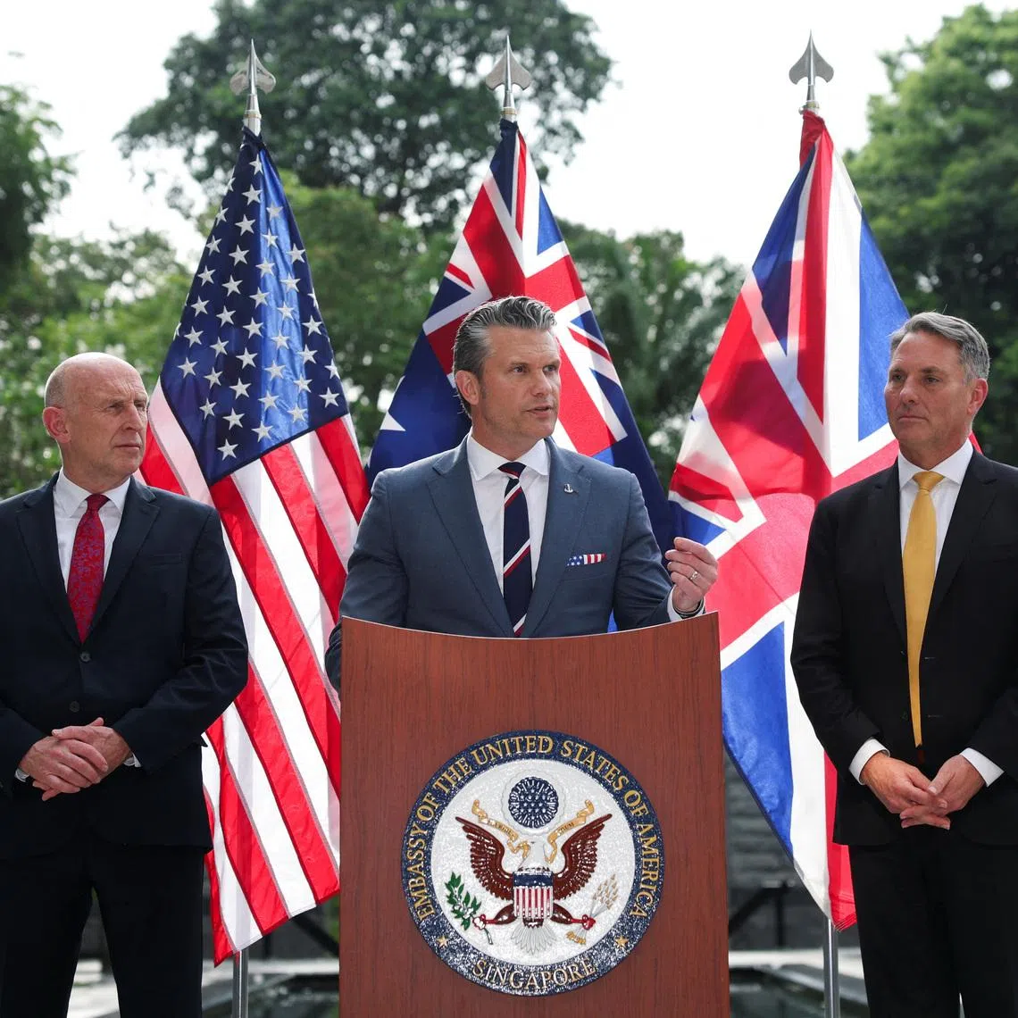 Australian Defence Minister Richard Marles and British Defence Secretary John Healey look on as U.S. Secretary of Defense Pete Hegseth speaks during an AUKUS Defence ministers' press huddle at the U.S. Embassy in Singapore, May 30, 2026. REUTERS/Edgar Su