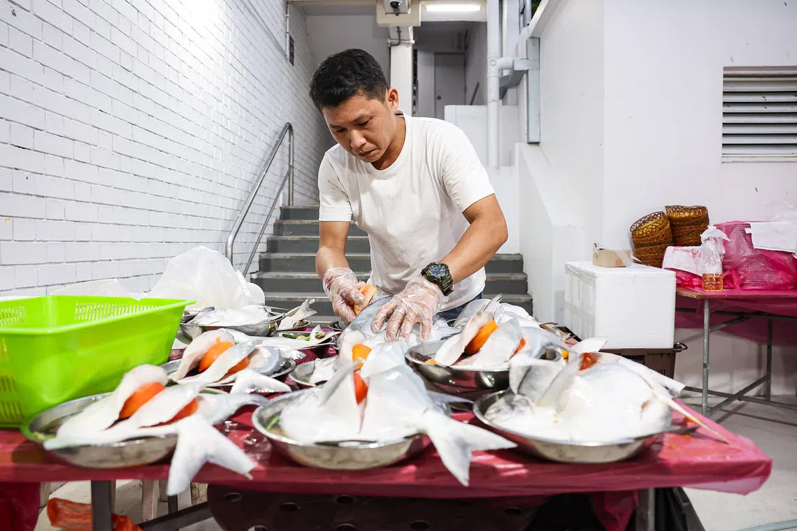 Staff of Gim Seng Heng Seafood Restaurant preparing a steamed pomfret dish ahead of the hungry ghost festival dinner auction at Toa Payoh on Aug 23, 2026. ST PHOTO: BRIAN TEO