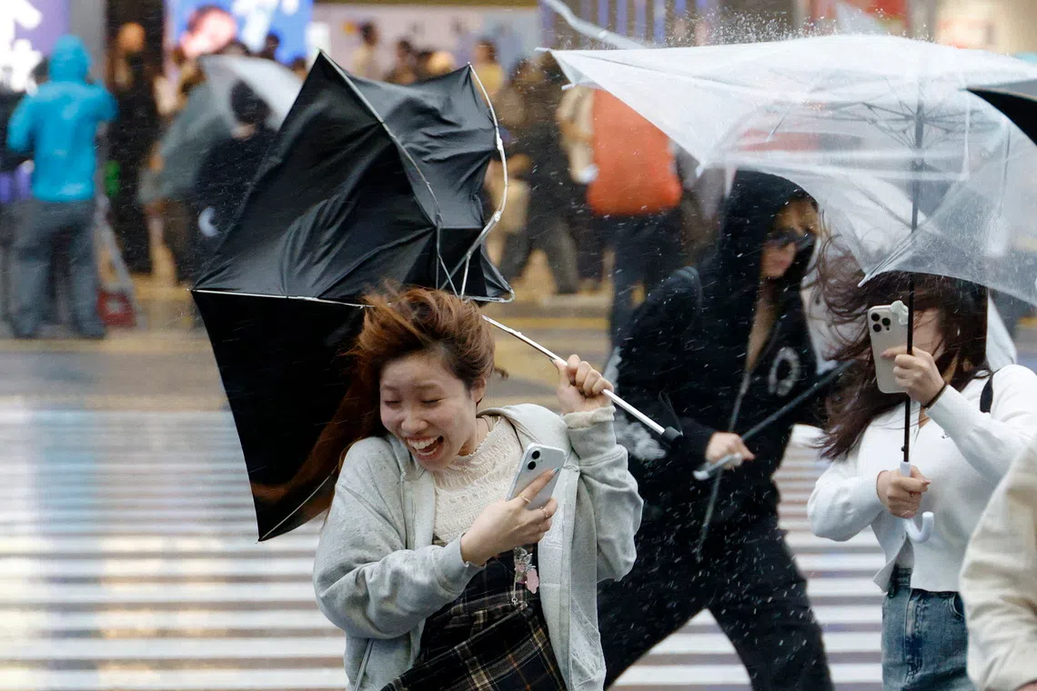 epa13253937 A young woman struggles to handle her umbrella under heavy rain and wind triggered by Typhoon Dujuan near Shinjuku station in Tokyo, Japan, 21 September 2026. Powerful and large Typhoon Dujuan approached the Boso Peninsula, Chiba Prefecture, near Tokyo, bringing heavy rain and disturbing transportation. EPA/FRANCK ROBICHON