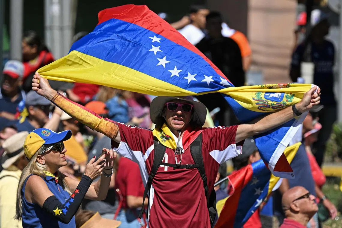A demonstrator waving a Venezuelan flag on Jan 9 in Caracas, during a protest by opponents of Mr Nicolas Maduro, on the eve of his inauguration as president, following a contested July election. 