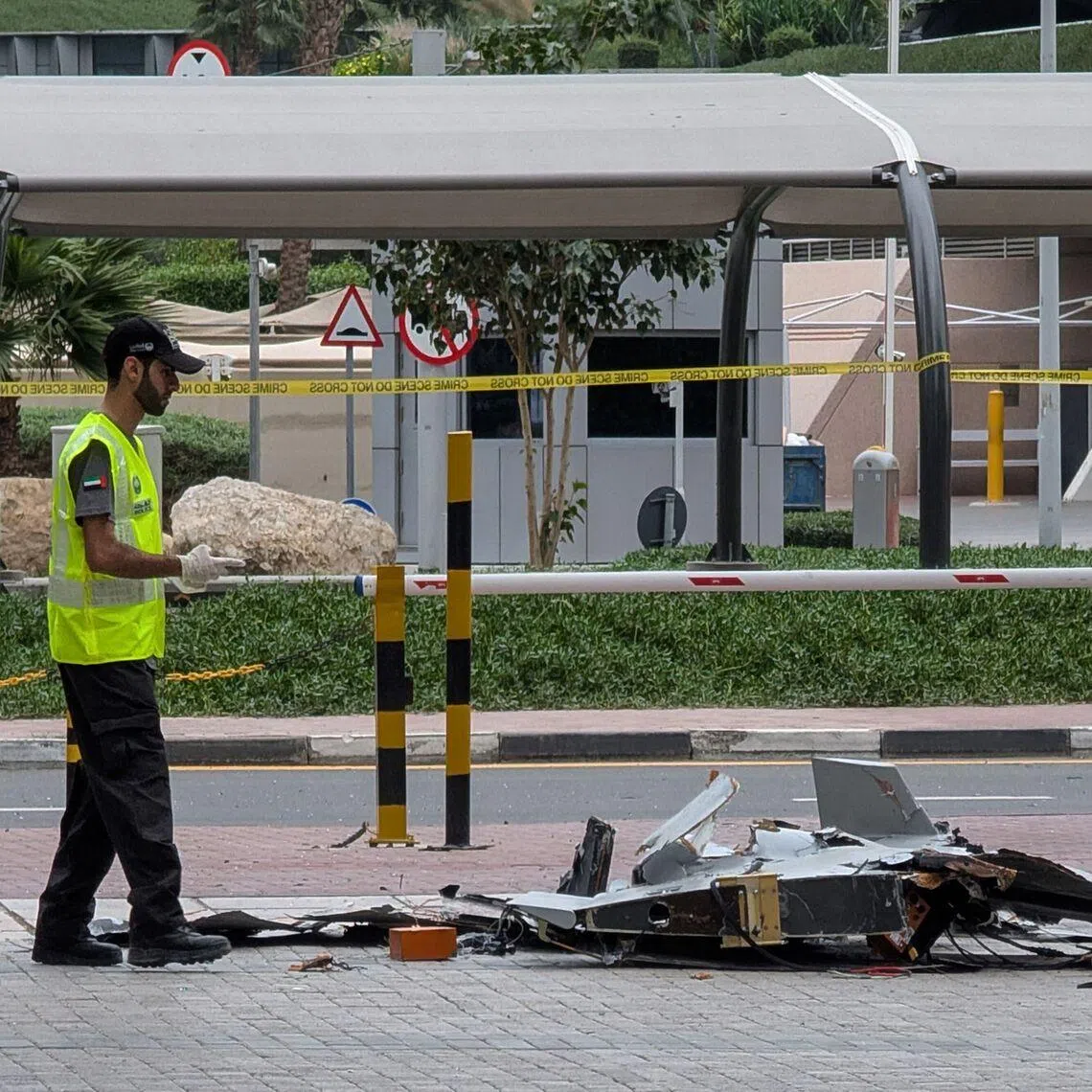 A police officer inspecting the wreckage of a drone in Dubai on March 12.