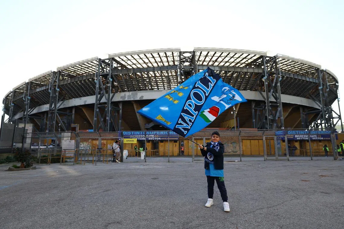 Soccer Football - Serie A - Napoli v U.S. Sassuolo - Stadio Diego Armando Maradona, Naples, Italy - January 17, 2026 A Napoli fan holds a flag outside the stadium before the match REUTERS/Ciro De Luca