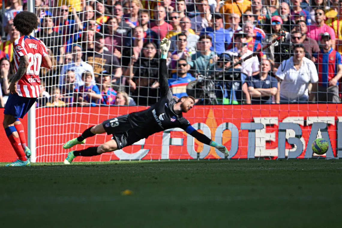 Atletico Madrid's Slovenian goalkeeper Jan Oblak fails to stop a goal by Barcelona's Spanish forward Ferran Torres.