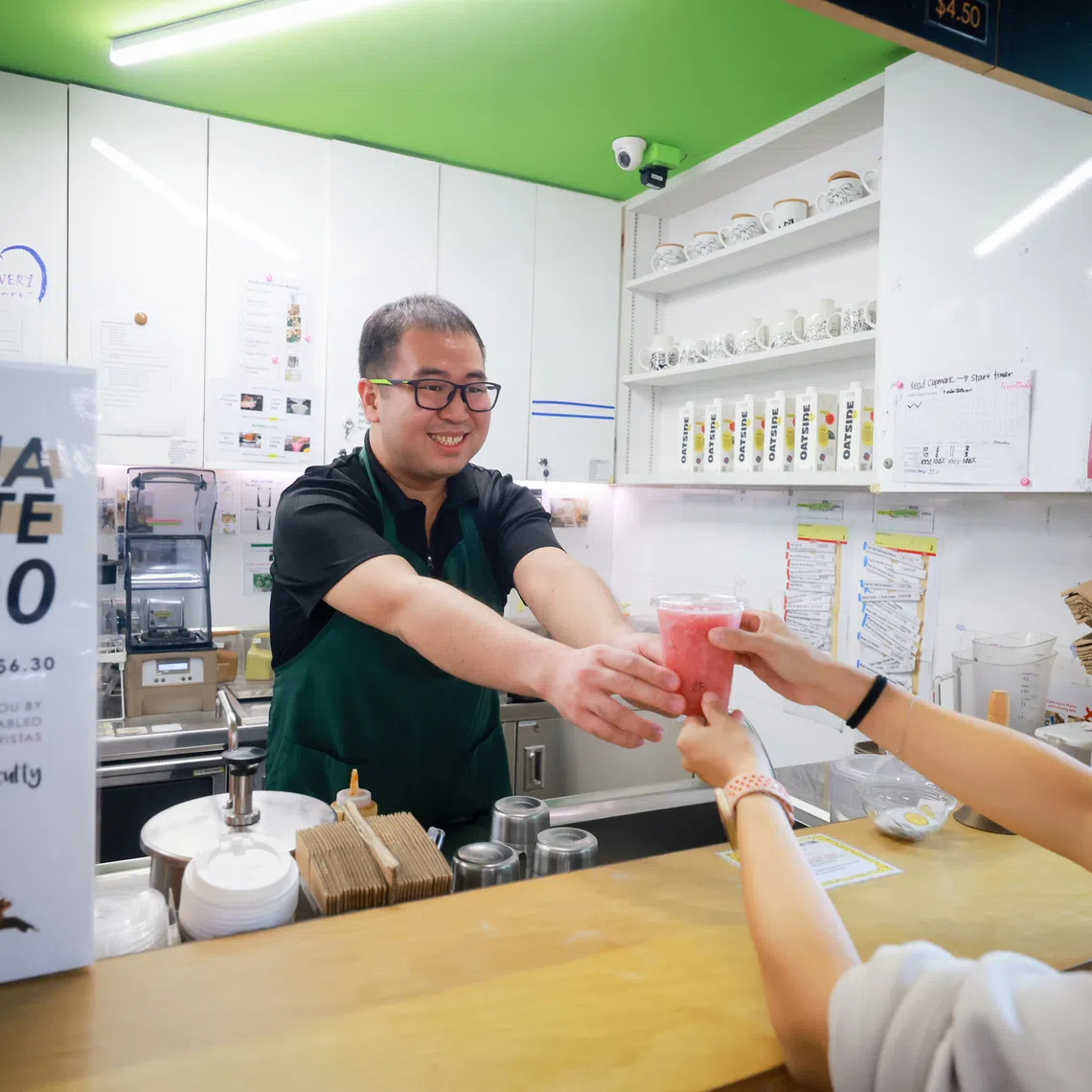 Barista Caleb Lim, 31, who has autism spectrum disorder, serving a customer at the Enabling Village's Art Bar on Oct 2.