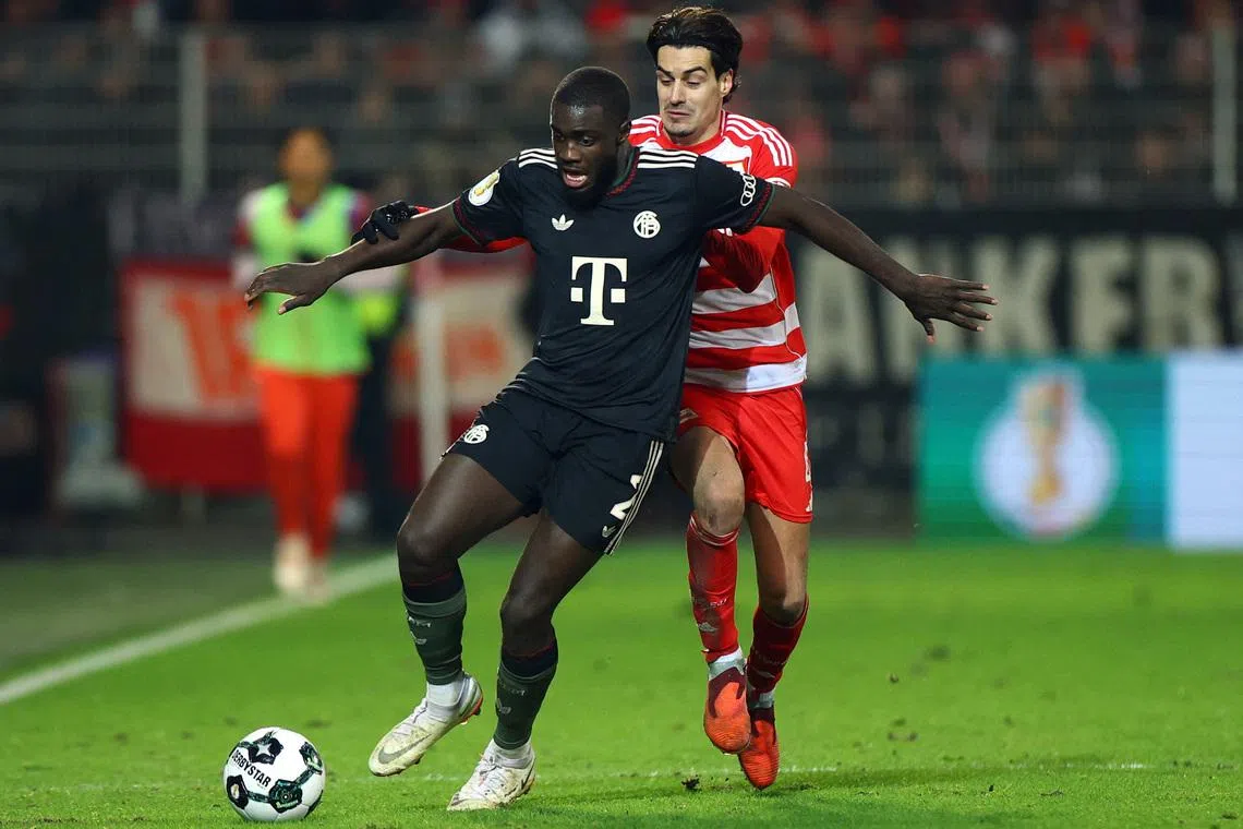 Soccer Football - DFB Cup - Round of 16 - 1. FC Union Berlin v Bayern Munich - Stadion An der Alten Forsterei, Berlin, Germany - December 3, 2025 Bayern Munich's Dayot Upamecano in action with 1. FC Union Berlin's Diogo Leite REUTERS/Lisi Niesner