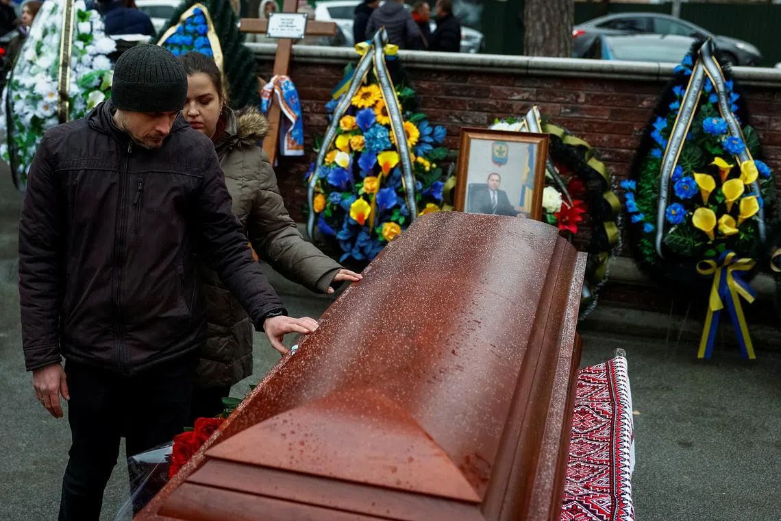 People pay tribute to mayor of the temporarily occupied town of Dniprorudne in Zaporizhzhia region Yevhen Matvieiev, who was abducted over two years ago and his body was returned to Ukraine during the latest exchange, amid Russia's attack on Ukraine, at a funeral ceremony, in the town of Bucha, Kyiv region Ukraine, December 5, 2024. REUTERS/Alina Smutko