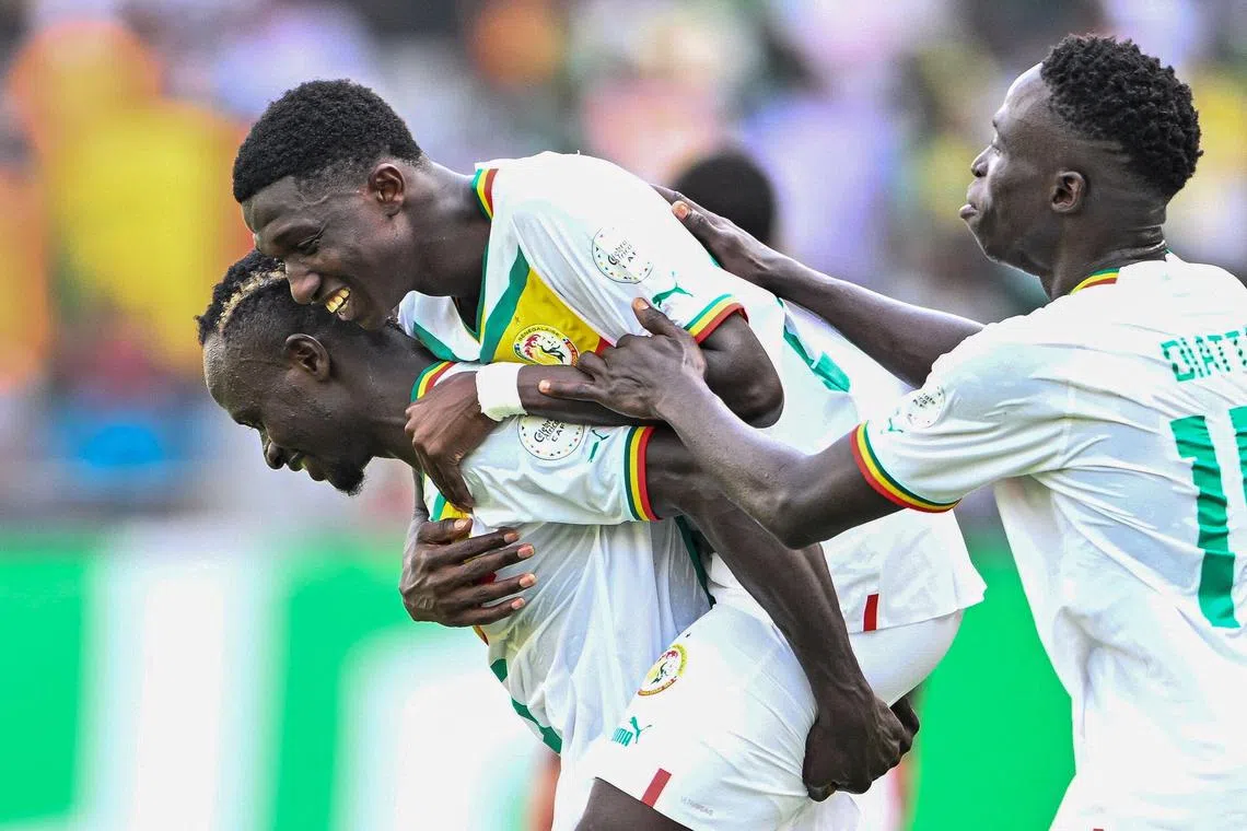 Senegal midfielder Lamine Camara (centre) celebrates with teammates after scoring his team's third goal in the 3-0 Africa Cup of Nations win over Gambia.