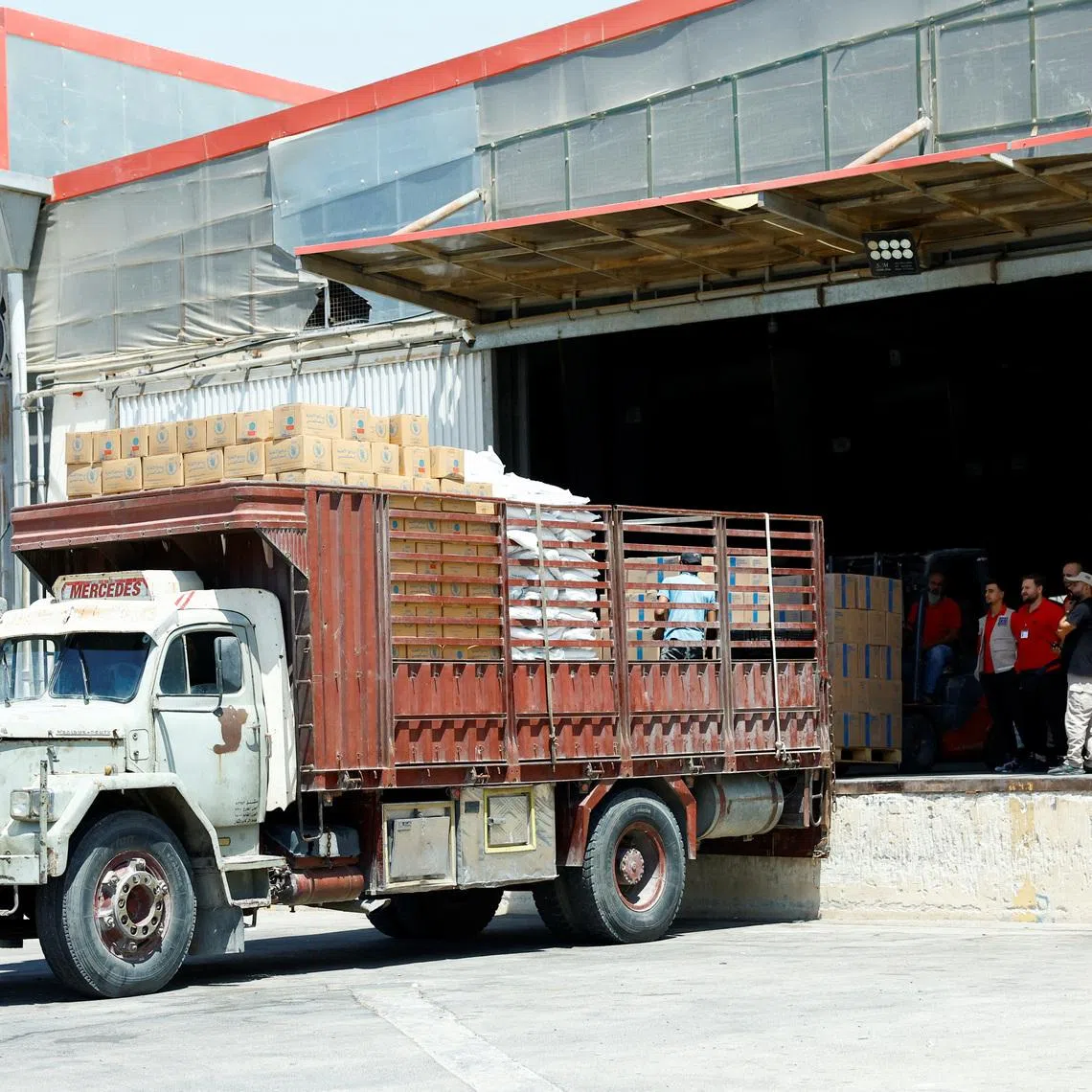 Workers load aid boxes onto a truck at a World Food Programme (WFP) facility in Damascus countryside, Syria, July 29, 2025. REUTERS/Yamam Alshaar