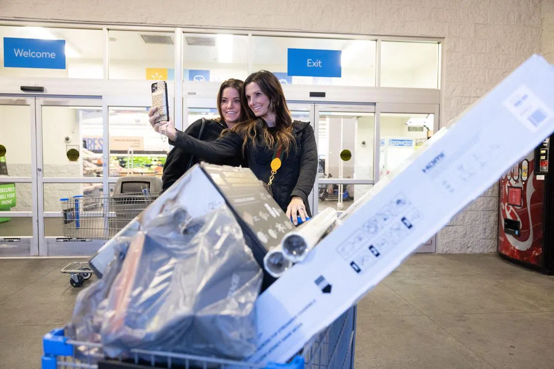 Sisters Janice Dawdy (left) and Karen Carter take a selfie after leaving Wal-Mart with Black Friday deals including a television and cookware.