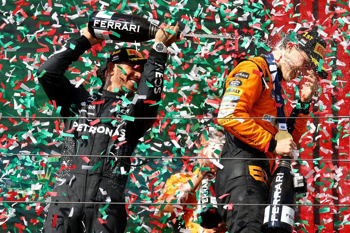 Formula One F1 - Hungarian Grand Prix - Hungaroring, Budapest, Hungary - July 21, 2024 Mercedes' Lewis Hamilton celebrates with champagne on the podium after finishing third place in the Hungarian Grand Prix with winner McLaren's Oscar Piastri REUTERS/Bernadett Szabo