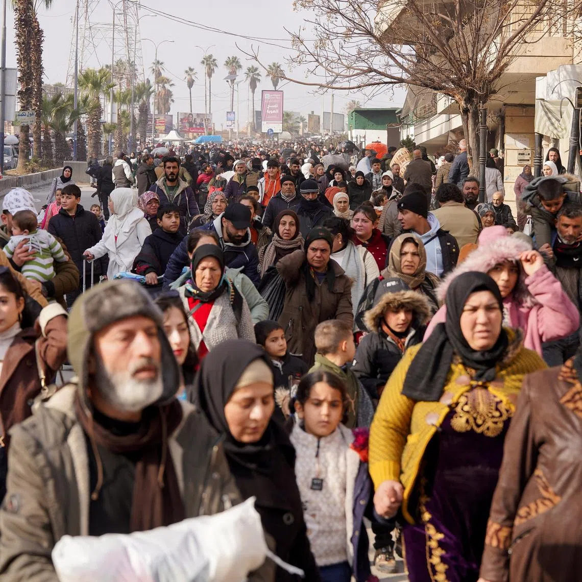 A group of civilians carry bags and belongings as they flee following renewed clashes between the Syrian army and the Syrian Democratic Forces, in Aleppo, Syria, January 7, 2026. REUTERS/Karam al-Masri