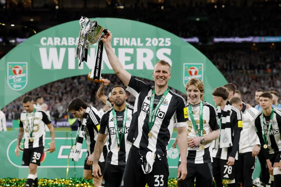 Soccer Football - Carabao Cup - Final - Liverpool v Newcastle United - Wembley Stadium, London, Britain - March 16, 2025 Newcastle United's Dan Burn celebrates with the trophy after winning the Carabao Cup. Action Images via Reuters/Andrew Couldridge