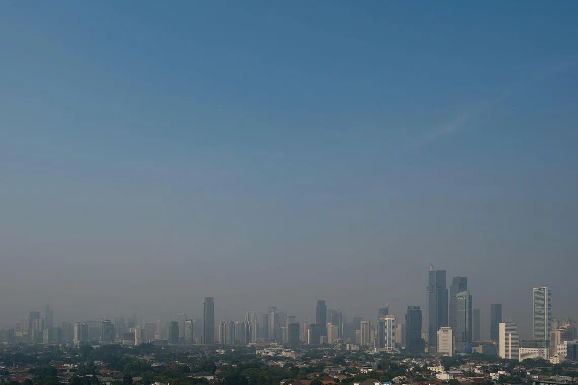 TOPSHOT - Buildings are seen in the haze caused by air pollution in Jakarta on August 25, 2023. The megalopolis of about 30 million people has seen air pollution levels rise to some of the highest in the world in recent months, topping global rankings multiple times since the beginning of August, according to Swiss air monitor IQAir. (Photo by Yasuyoshi CHIBA / AFP)