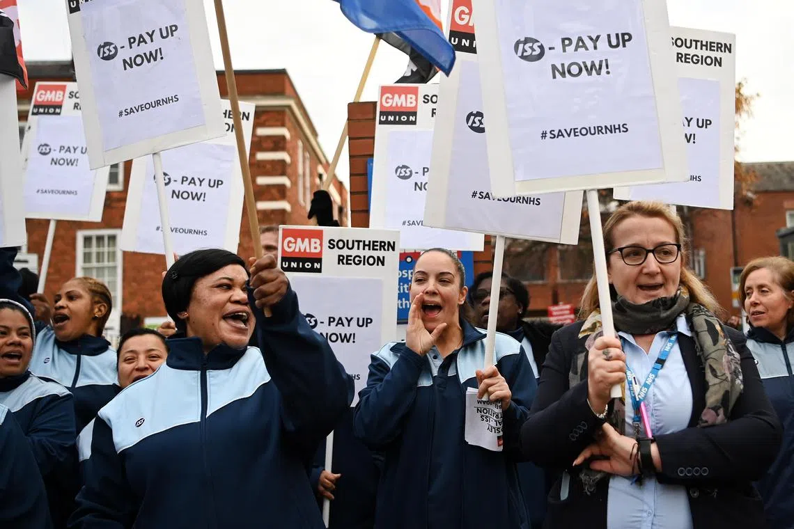 epa10341108 NHS domestic cleaners hold placards during a strike outside a hospital in London, Britain, 01 December 2022. NHS domestic cleaners are striking over an on-going dispute over pay and conditions.  EPA-EFE/ANDY RAIN