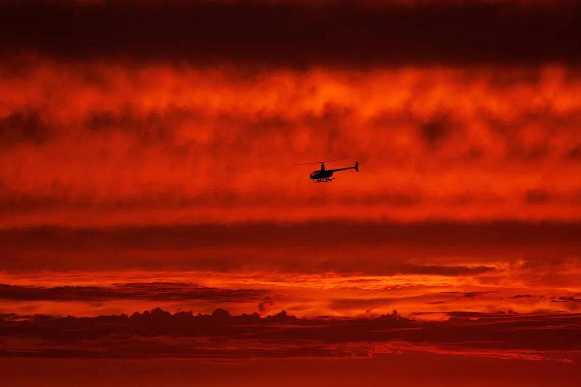 A helicopter traveling  south along the coast after sunset over the ocean as hurricane Hilary approaches Del Mar, California, U.S on August 19, 2023. 