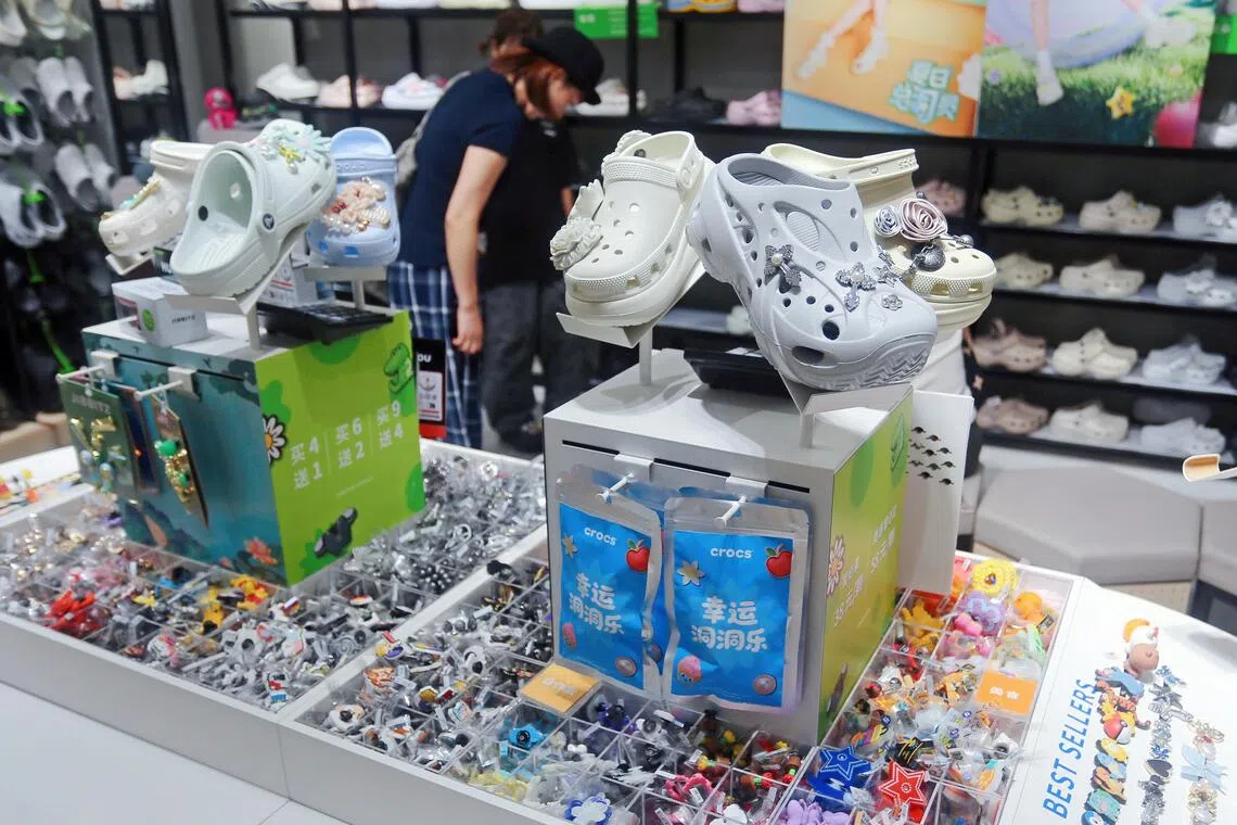 Customers purchase Holey Fashion Shoes in a Crocs store in Shanghai, China on July 3, 2025. 