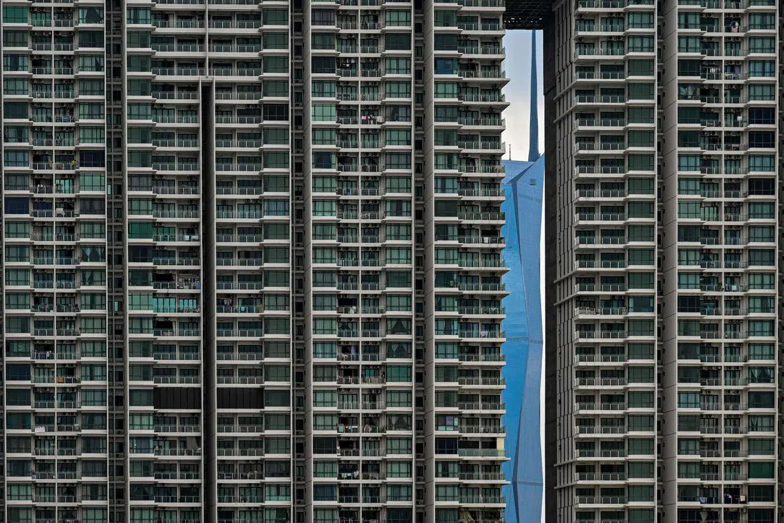 The Warisan Merdeka Tower (KL118) (right), the second tallest building in the world, is pictured through a residential building in Kuala Lumpur on May 15, 2024. 