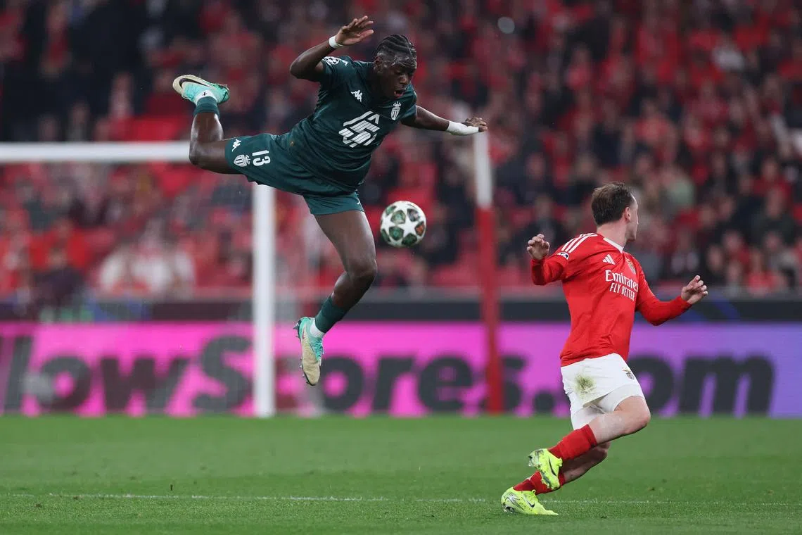 Monaco's French defender, Christian Mawissa (left) is airborne as he goes for the ball during the UEFA Champions League knockout phase play-off second leg football match between SL Benfica and AS Monaco at Luz stadium, in Lisbon, on Feb 18, 2025. 