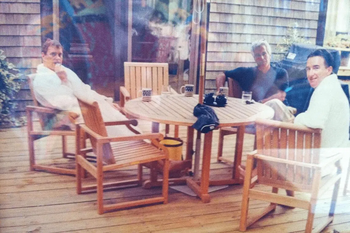 Andrew Mountbatten-Windsor and Lord Peter Mandelson are seen wearing bathrobes seated alongside late financier and convicted sex offender Jeffrey Epstein, in an undated photograph released by the Department of Justice in Washington, D.C., U.S., as part of a trove of documents from its investigations into Epstein. U.S. Justice Department/Handout via REUTERS THIS IMAGE HAS BEEN SUPPLIED BY A THIRD PARTY. 
