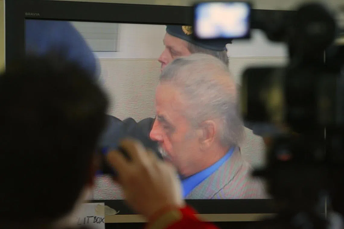 FILE PHOTO: Journalists watch a TV screen inside the media tent as 73-year-old Austrian Josef Fritzl appears in court on the fourth day of his trial in St. Poelten March 19, 2009. REUTERS/Heinz-Peter Bader/File Photo