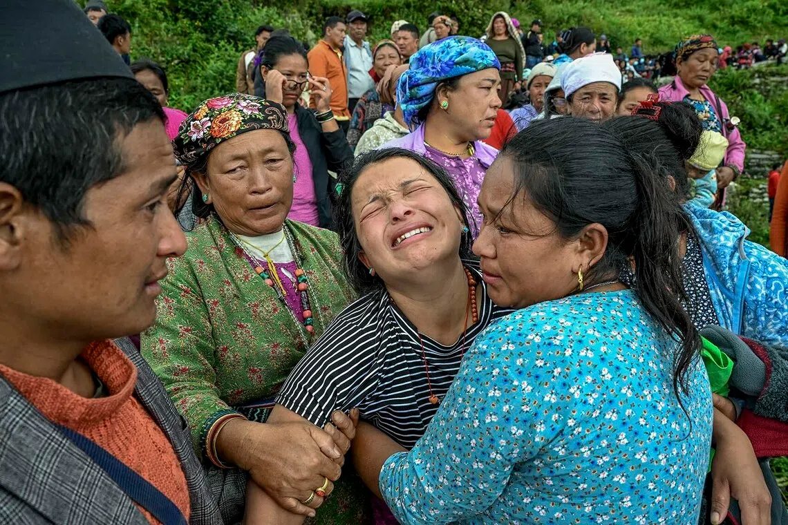 A woman is overcome with grief as she waits for her turn to board a rescue helicopter in the disaster-stricken Rasuwa district near NepalÕs border with Tibet, on Thursday, Aug. 27, 2026. A visit near NepalÕs border with Tibet laid bare the effects of a swollen riverÕs furious speed, with miles of devastation left behind by a deadly flash flood. (Atul Loke/The New York Times)