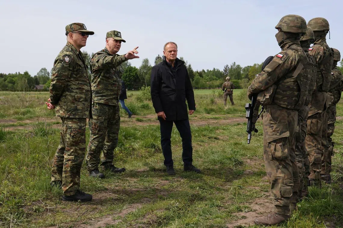 Polish Prime Minister Donald Tusk (centre) visiting Poland's border with Russia-allied Belarus, on May 11.