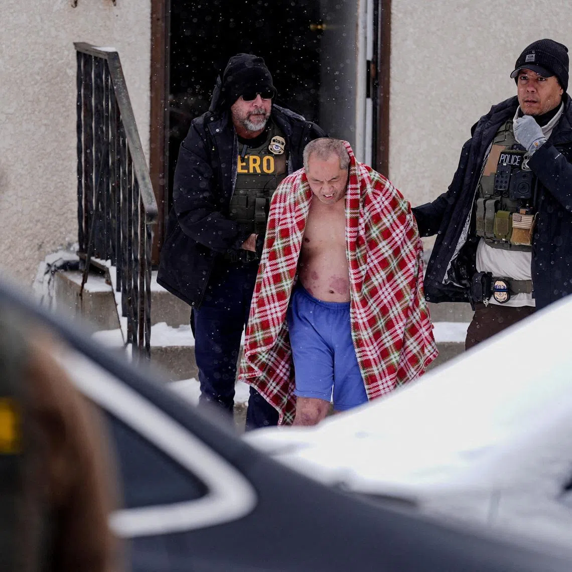 A man, whose family requested a Hmong interpreter, is detained after ICE agents and other law enforcement officers conducted an immigration raid at his home, days after an ICE agent fatally shot Renee Nicole Good, in St. Paul, Minnesota, U.S., January 18, 2026. REUTERS/Leah Millis