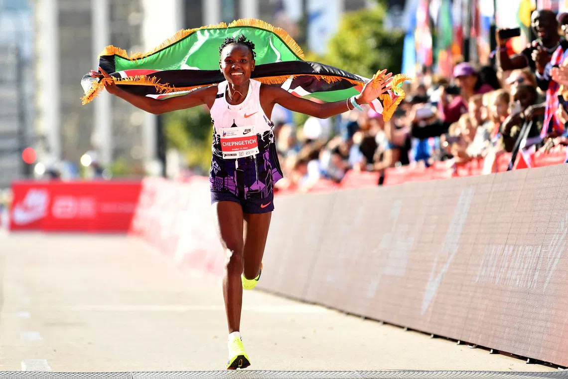 Oct 13, 2024; Chicago, IL, USA; Ruth Chepngetich of Kenya celebrates after finishing first in the women’s race, setting a new world record at 2:09:56 during the Chicago Marathon at Grant Park. Mandatory Credit: Patrick Gorski-Imagn Images