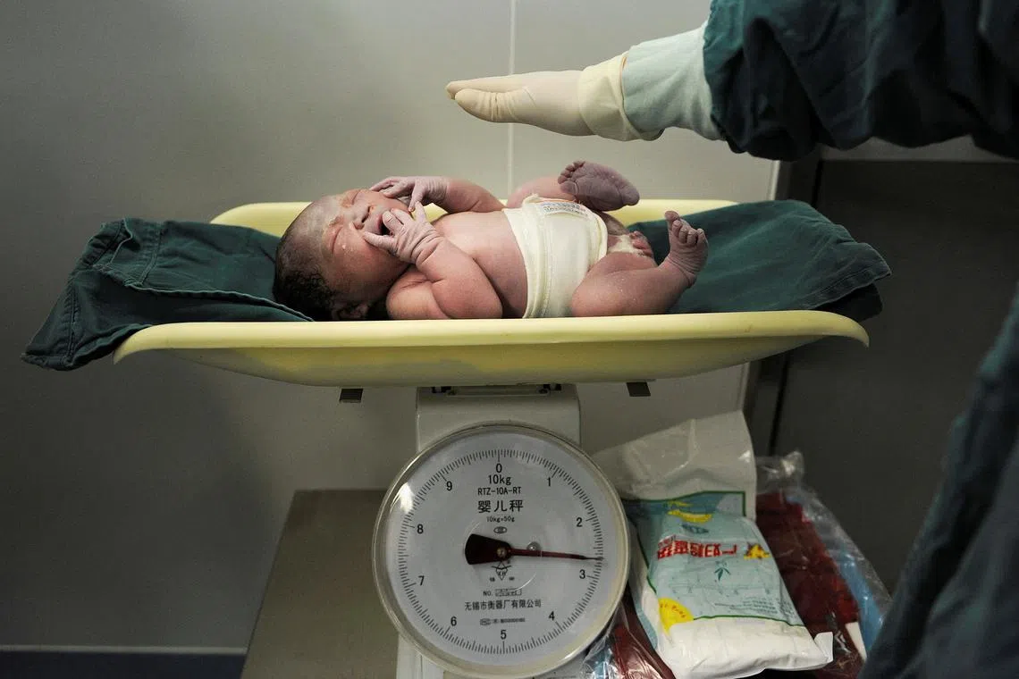 FILE PHOTO: A newborn baby is weighed after it was born at a hospital in Hefei, Anhui province October 31, 2011. REUTERS/Stringer/File Photo
