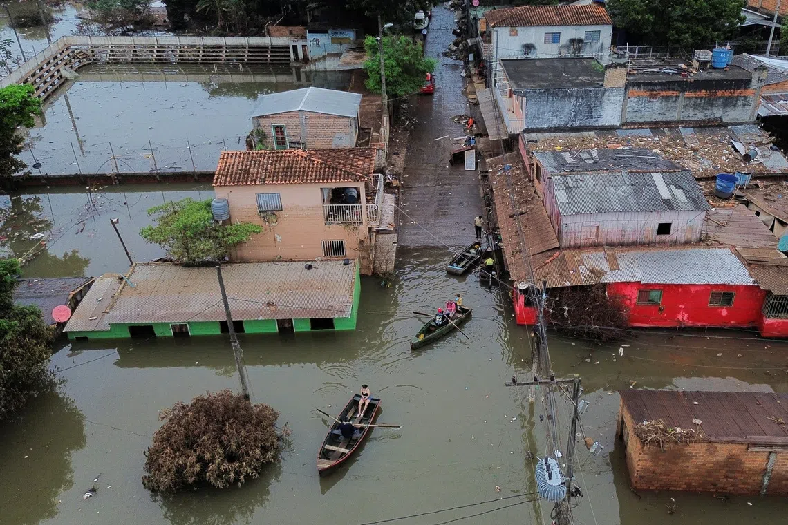 A drone view shows people traveling by boats through a flooded neighborhood after heavy rains, in Ciudad del Este, Paraguay, October 21, 2026. REUTERS/Cesar Olmedo