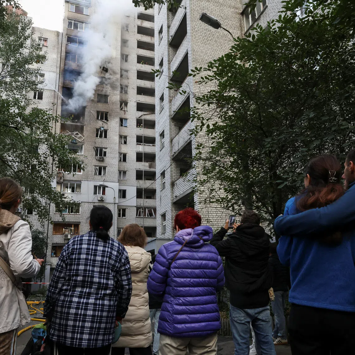 People gather at the site of an apartment building which was hit by a Russian jet drone strike, amid Russia's attack on Ukraine, in Kyiv, Ukraine September 25, 2026. REUTERS/Thomas Peter