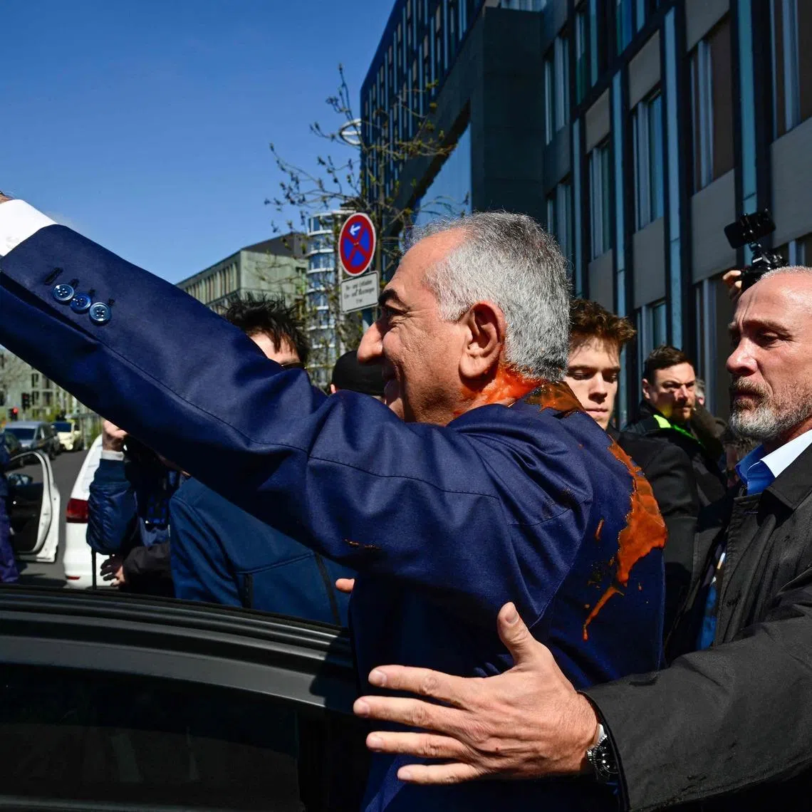 Mr Reza Pahlavi, the exiled son of Iran's last shah, was approached from behind by an unidentified man who splashed him with a red liquid.