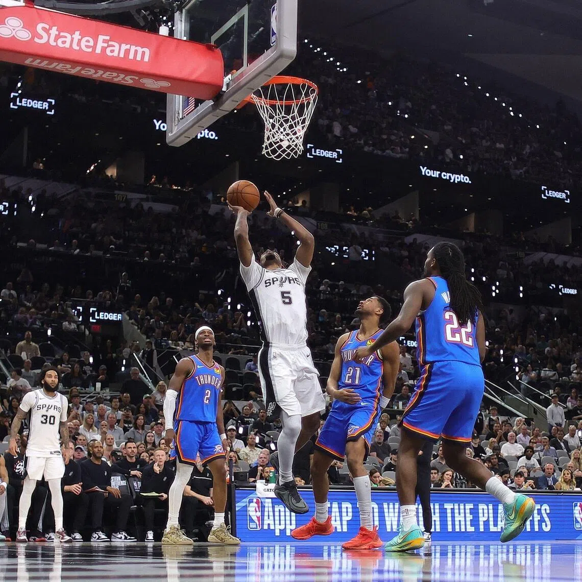 Stephon Castle of the San Antonio Spurs attempts a shot against Aaron Wiggins and Shai Gilgeous-Alexander of the Oklahoma City Thunder during the third quarter in Game 4.