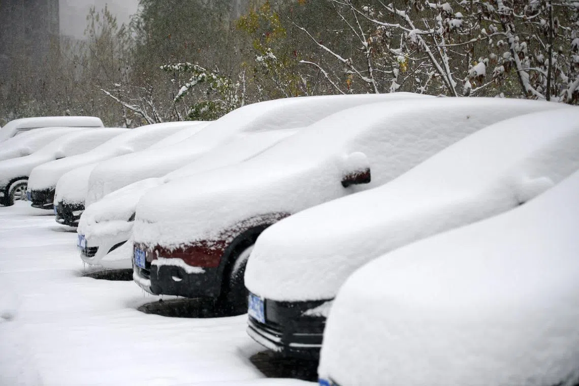 Snow-covered cars are seen during snowfall in Shenyang, in China's northeastern Liaoning province on November 6, 2023. (Photo by AFP) / China OUT