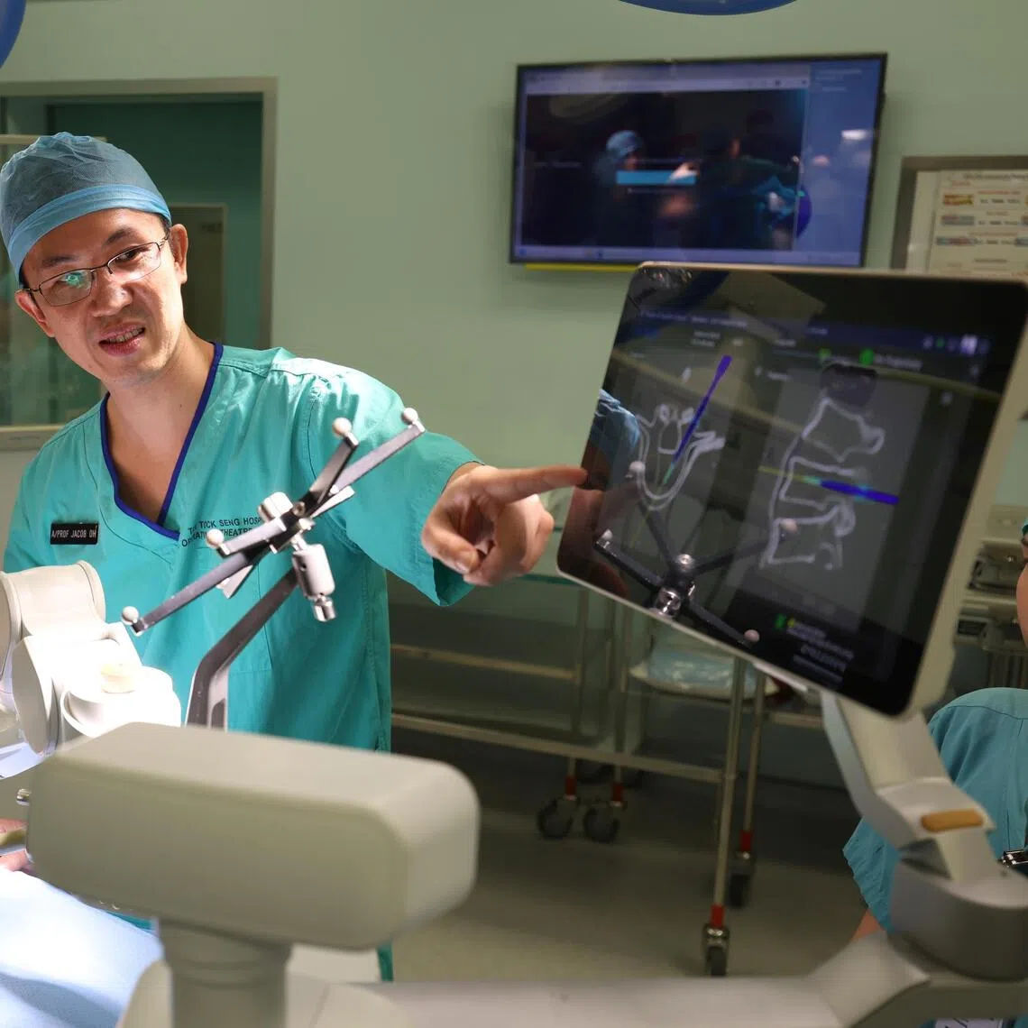 Adj A/Prof Jacob Oh (right), head of spine surgery and a senior consultant from the department of orthopedic surgery at TTSH, and Dr Wayne Yap, a consultant from the same department, demonstrating how the AI tool assisted the planning and execution of complex spine surgeries.