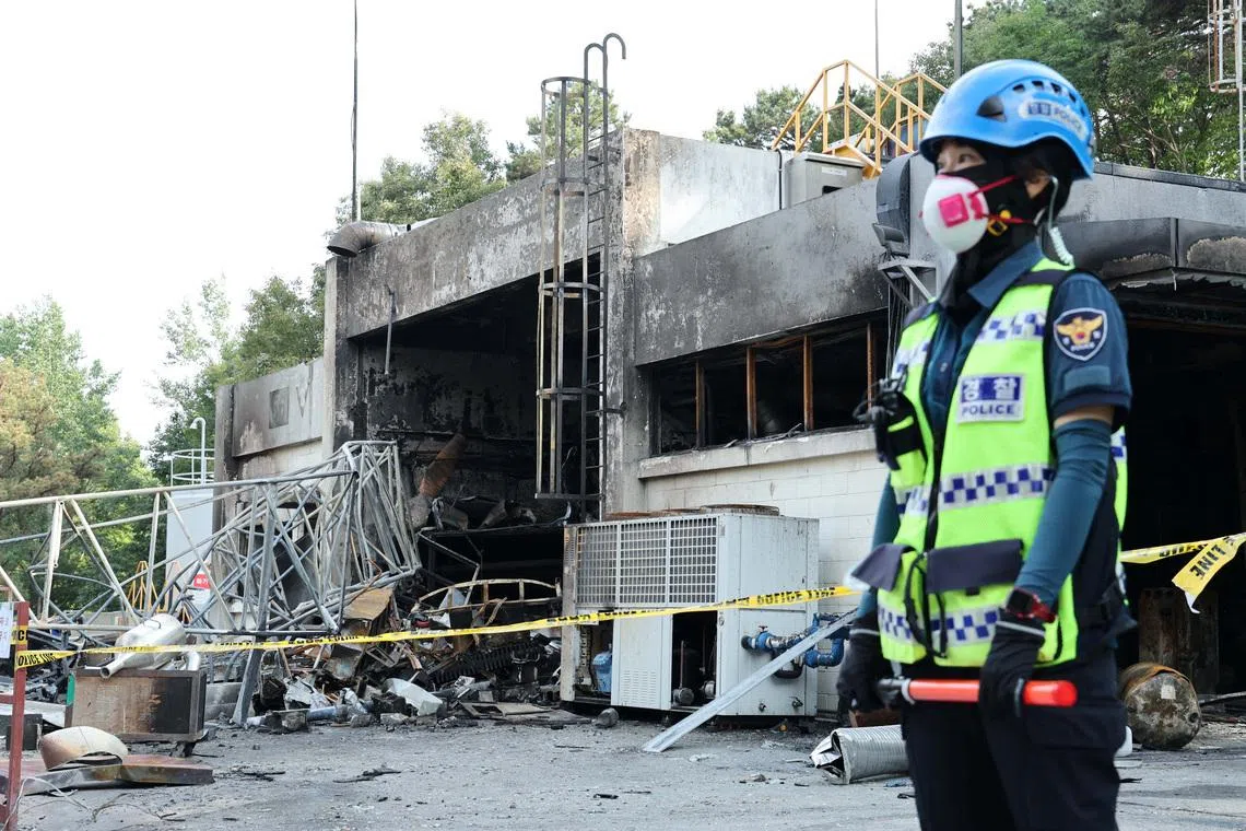 A police officer stands in front of heavily damaged production line for rocket propellant of Hanwha Aerospace's factory after an explosion, in Daejeon, South Korea, June 1, 2026.    Yonhap via REUTERS