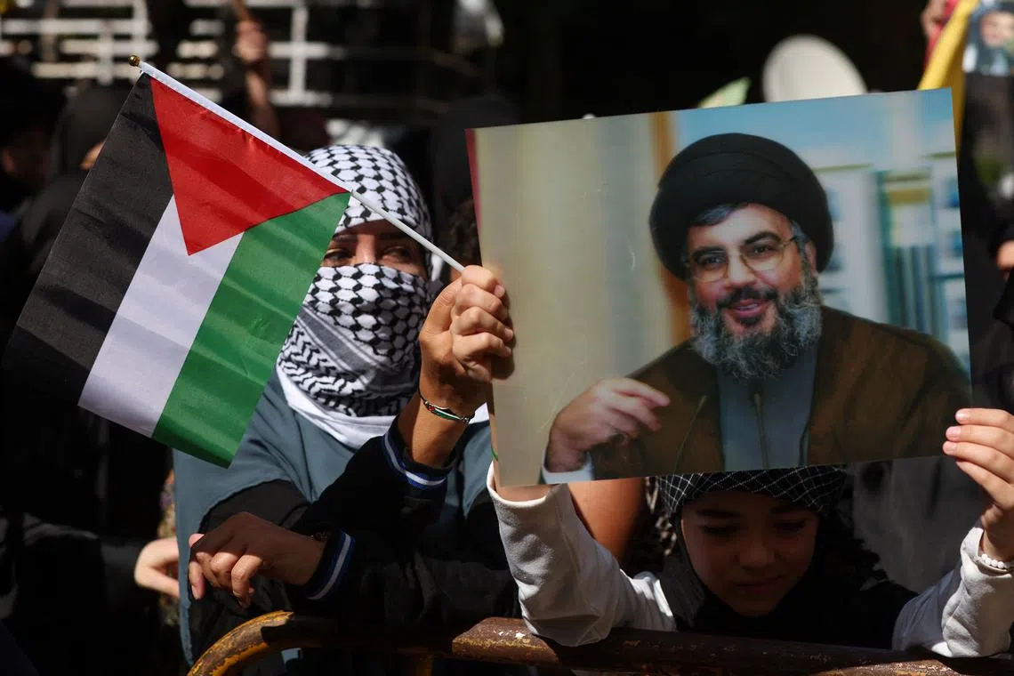 FILE PHOTO: Hezbollah supporters carry flags and banners depicting Hezbollah senior official Sayyed Hashem Safieddine during a protest in Beirut's southern suburbs, Lebanon October 18, 2023. REUTERS/Mohamed Azakir/File Photo