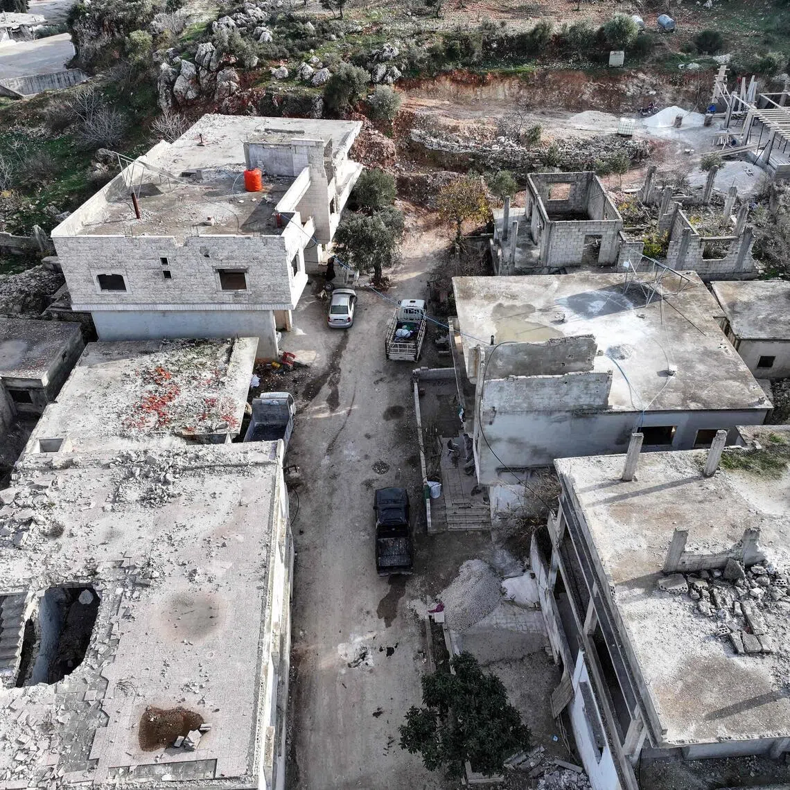 A aerial view of al-Ghassaniya, a mainly Christian town in central Syria, south of the city of Homs, as it residents begin to return to their destroyed homes and businesses after they fled during the Syrian civil war, on December 14, 2025. During the 14-year Syria civil war, Islamic Jihadist groups were active in the areas of Northwestern Syria, with many of the local Christian community abandoning their towns and villages and settling mainly in former president Bashar al-Assad regime-controlled areas. (Photo by Omar HAJ KADOUR / AFP)