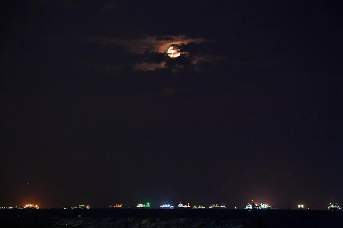 The blue supermoon, partially obscured by clouds, is seen from East Coast Park on Aug 31, 2023.