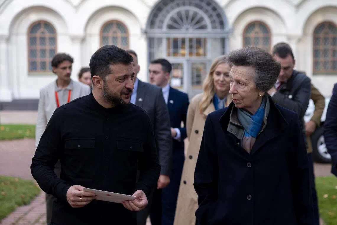 Ukrainian President Volodymyr Zelensky holding a letter he received from Britain's Anne, as they visit St. Sophia's Cathedral in Kyiv, Ukraine, on Sept 30.