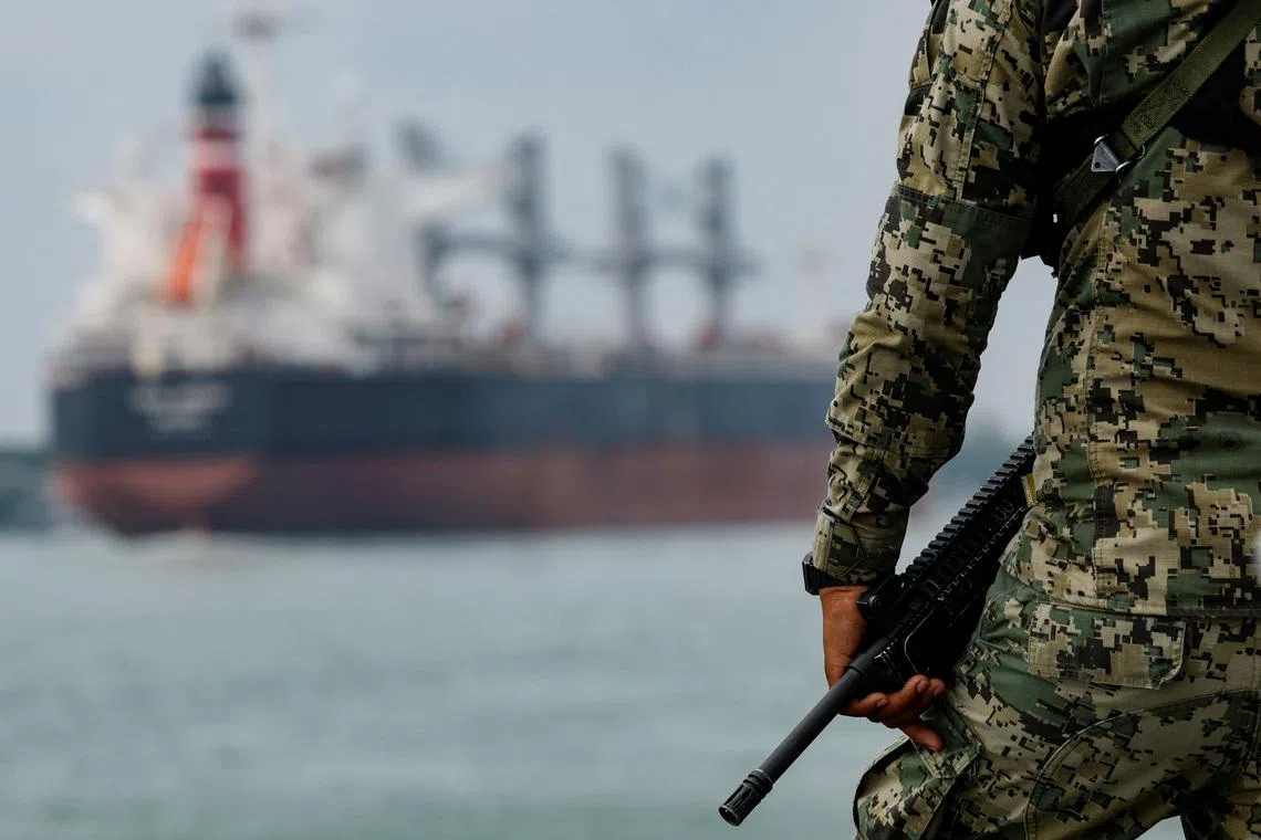 A member of the Mexican navy holds his rifle while patrolling in a boat as Mexico expands probe into cartel-linked maritime fuel‑smuggling at key ports, in Ciudad Madero, Mexico, May 28, 2025. REUTERS/Daniel Becerril