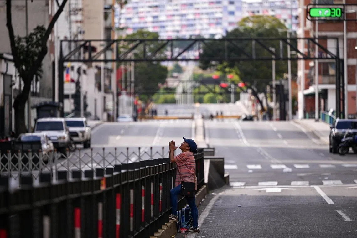 A woman prays outside the Vice-Presidency building, following a US strike on Venezuela where President Nicolas Maduro and his wife, Cilia Flores, were captured, in Caracas, Venezuela, on Jan 3, 2026.
