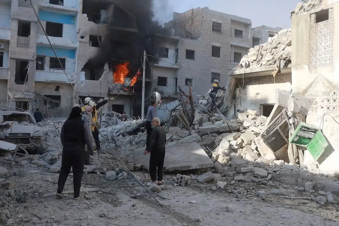 White Helmets members work next to a damaged building at the scene of what the organisation says is a strike, at a location given as Idlib, Syria, released December 2, 2024, in this still image taken from a handout video. The White Helmets/Handout via REUTERS
