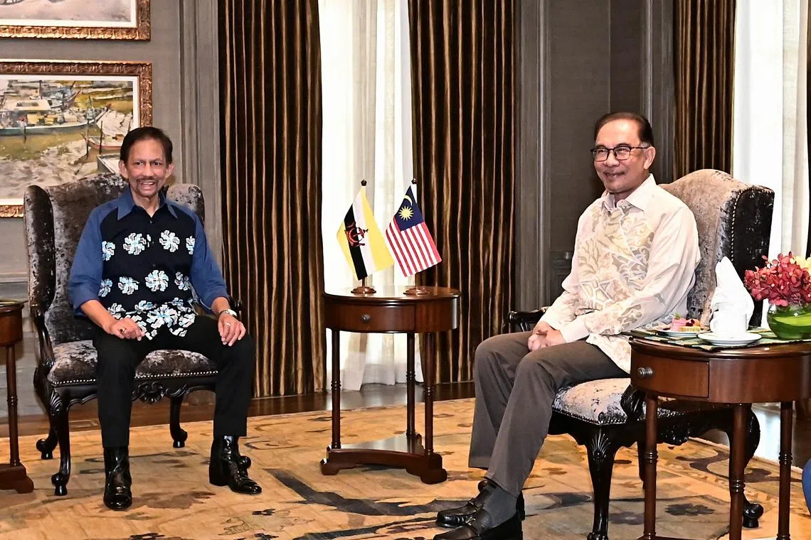 Malaysia's PM Anwar Ibrahim (right) with Brunei's Sultan Hassanal Bolkiah at the Prime Minister's office in Malaysia on Nov 28, 2022.