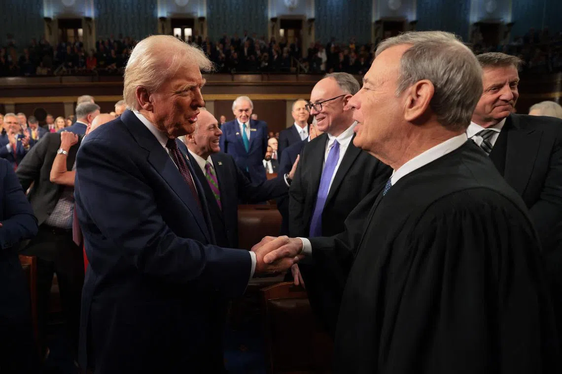 (FILES) US President Donald Trump (L) greets Chief Justice of the United States John Roberts as he arrives to speak during an address to a joint session of Congress at the US Capitol in Washington, DC, on March 4, 2025. Roberts issued a rare rebuke of President Trump on March 18, 2025, over his attack against a federal judge, bringing a smoldering conflict between the Republican and the judiciary into the open, US media reported. (Photo by Win McNamee / POOL / AFP)