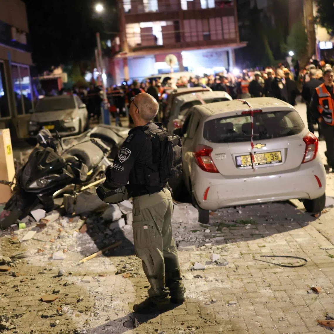 First responders inspect the damage at the site of a missile strike in Ramat Gan, in the outskirts of Tel-Aviv, Israel on March 18, 2026. (Photo by Ilia YEFIMOVICH / AFP)