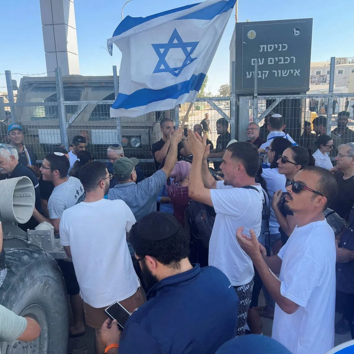 FILE PHOTO: Right-wing protesters wave Israeli flags outside Sde Teiman detention facility, after Israeli Military Police arrived at the site as part of an investigation into suspected abuse of a Palestinian detainee, near Beersheba in southern Israel, July 29, 2024. REUTERS/Jill Gralow/File Photo