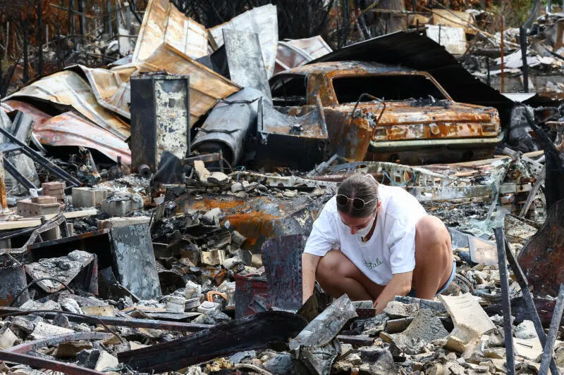 A resident inspects the charred remains of her parents’ home after it was destroyed by a wildfire in Le Porge, in France’s Gironde department, on Aug 3, after authorities allowed evacuees to return to the area.